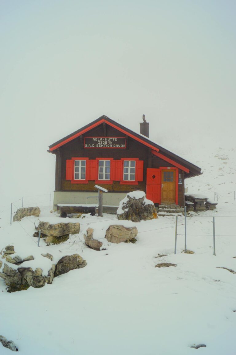 A serene alpine hut surrounded by snow in Switzerland's mountainous region.